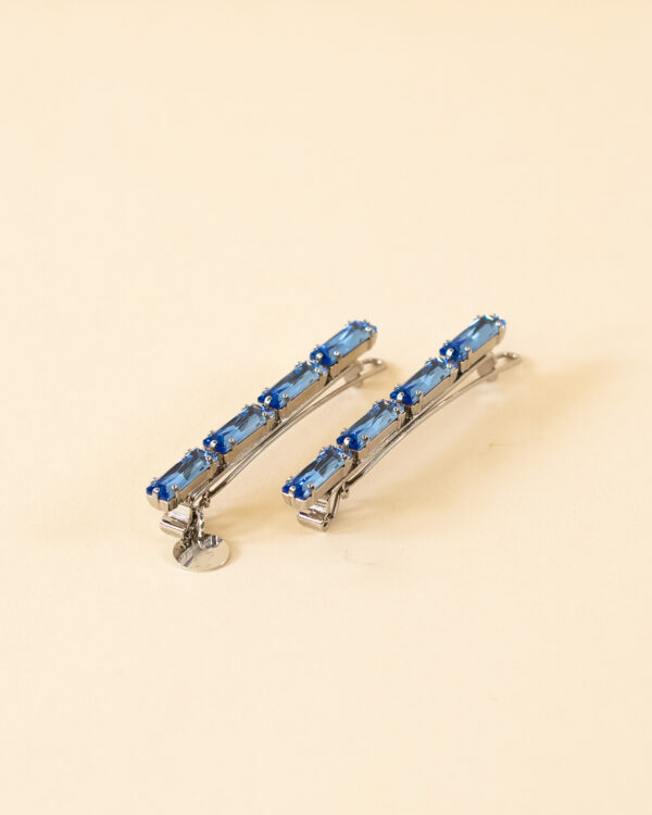 kit di due fermagli per capelli con chiusura a scatto, base di colore argento e cristalli a forma di baguette colore blu